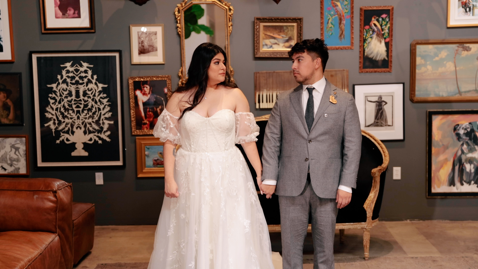 bride and groom in front of wall of photographs at Playa Studios