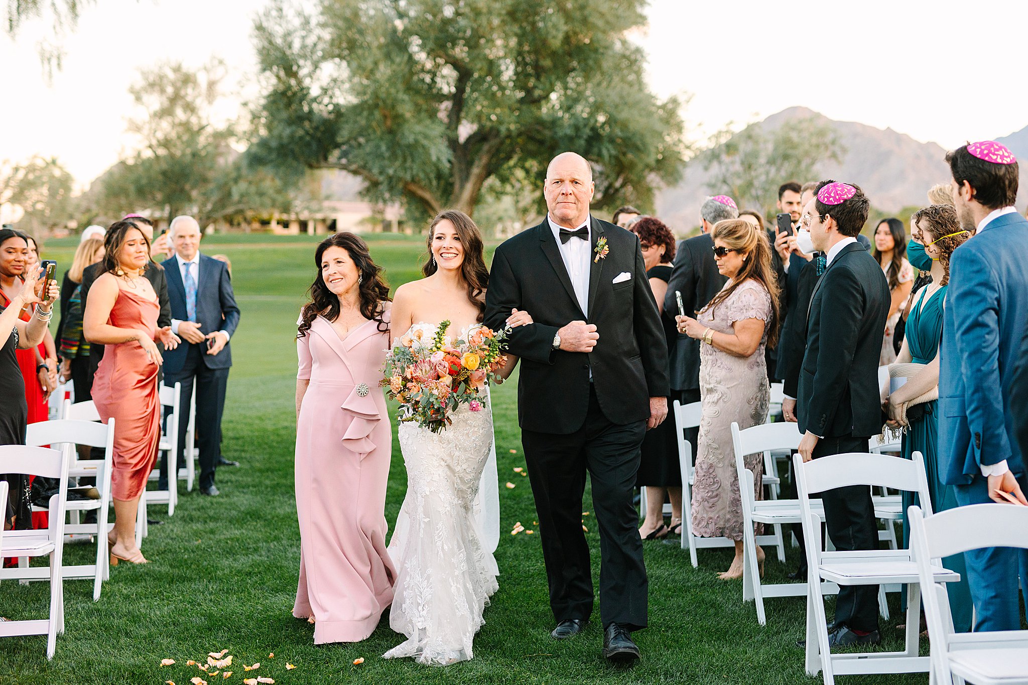 Bride walking down the aisle with mother and father