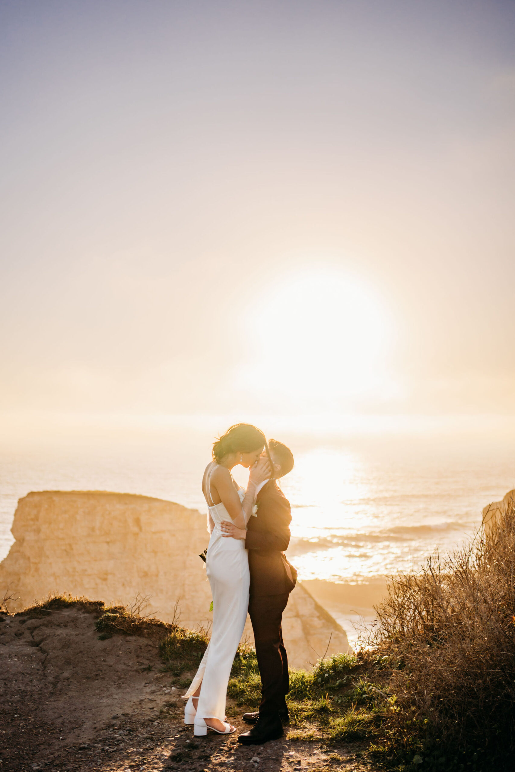 Bride and Bride kiss at Shark fin cove in santa curz