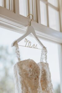 Close-up of a wedding dress on a hanger that says, "Mrs."