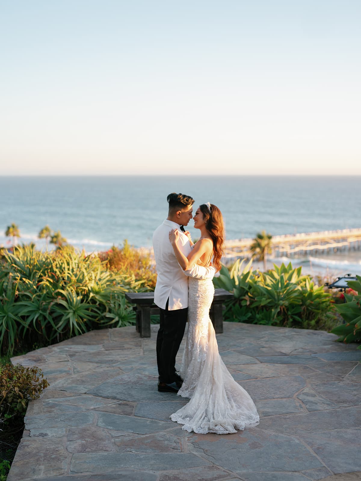 San Clemente wedding couple dances on a patio with ocean views behind them