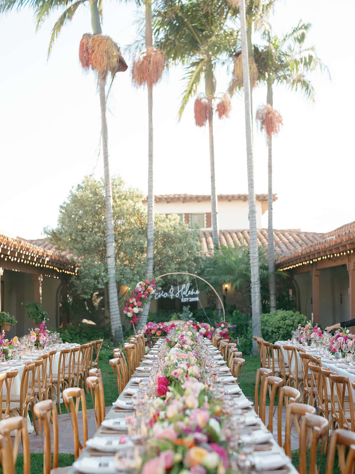 Casa Romantica reception with pink and white florals and a neon sign