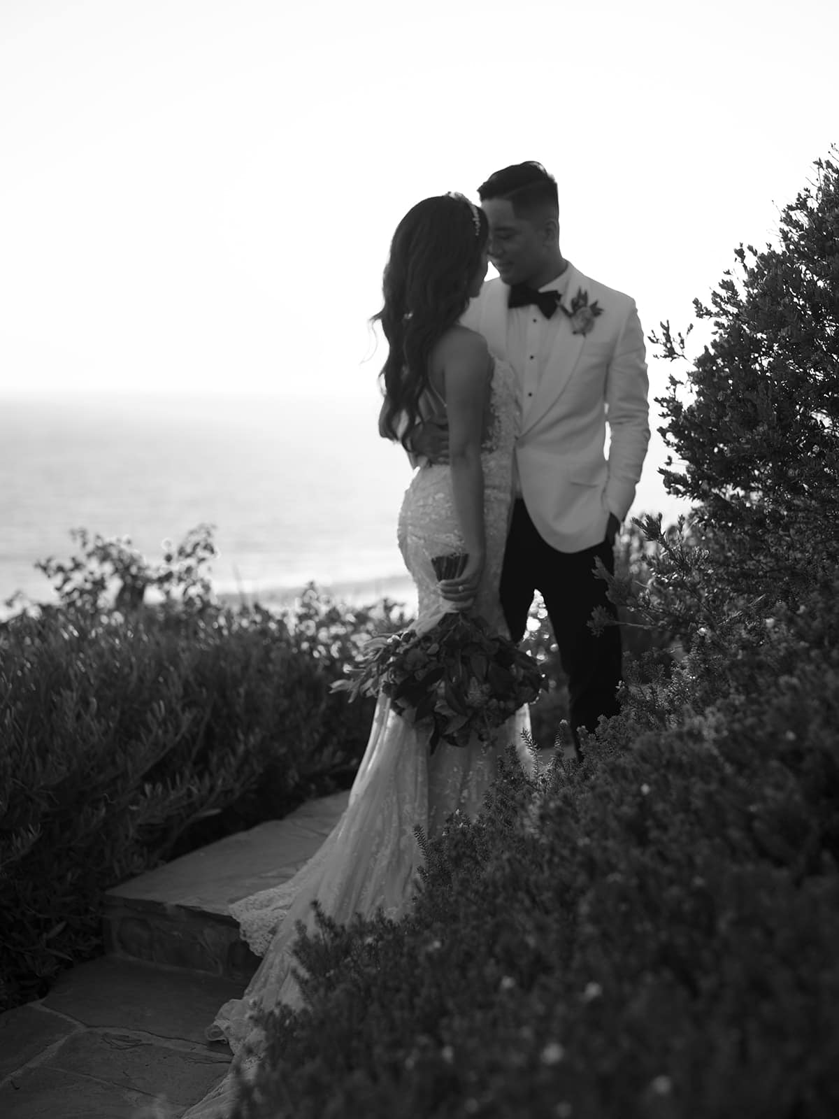 Black and white photo of a couple standing close together on a trail by the Casa Romantica wedding venue
